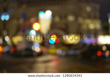 Blurred abstract photo of night street with bright lights, cars and buildings.