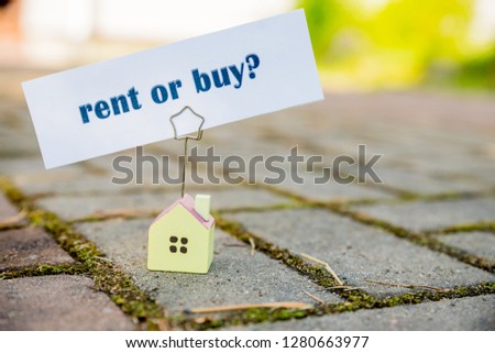 Text message Buy or rent on small house Photo holder. Business concept.hard chouce. loans, Bank debt, financial problems, the issue of new housing.Finance Concept.Talking Communication BUY OR RENT 