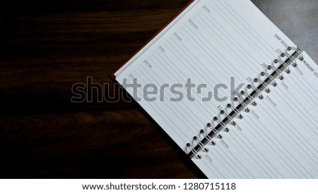 Top view of a spiral notepad on an wooden table. Concept of education, business, finance and office work
