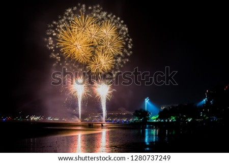 Fireworks over city skyline with reflections on water  Royalty-Free Stock Photo #1280737249