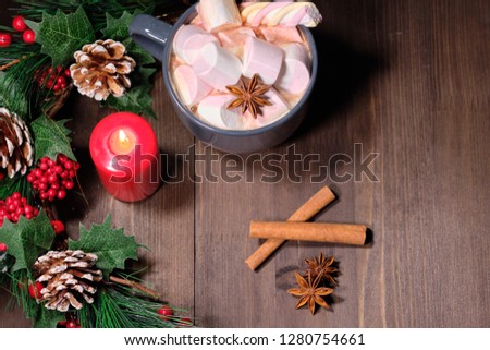  marshmallow in grey cup on brown wood background with Christmas tree ,  candles and christmas lights. Close up