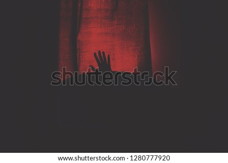 a creepy hand in the dark with a red bloody background