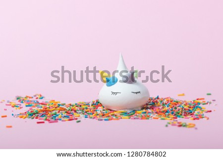 Meringue in the form of a unicorn on a pink background.Unicorn cake on a pink background.Color confectionery dressing.Pastel colors.Place for text.