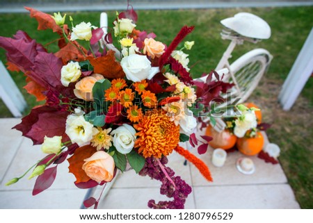 Bicycle decorated with autumn flowers, leaves and pumpkins