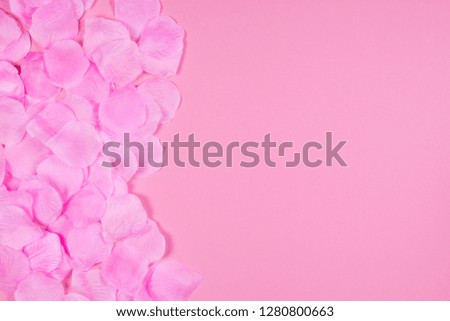 Artificial tender and delicate pink rose petals on the background of the same tone.