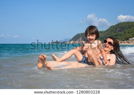 Mother and son playing on the beach. Family having fun on beach on travel vacation summer holidays