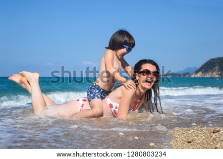 Mother and son playing on the beach. Family having fun on beach on travel vacation summer holidays