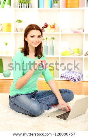 Beautiful young woman working on laptop in room