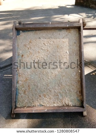 Wooden frame with a sheet of handmade mulberry paper drying in the midday sun. 