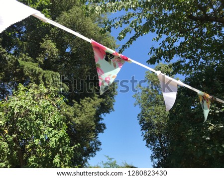 Celebration party bunting fluttering in the breeze against a bright, blue sky 