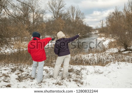 Woman and the boy on the Bank of the Świder river during the winter. 