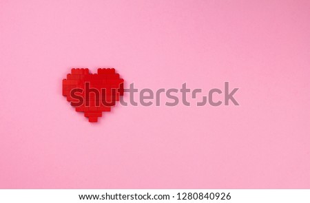 One red heart from the designer details on a pink background, lightness and romance for Valentine's day, love art concept