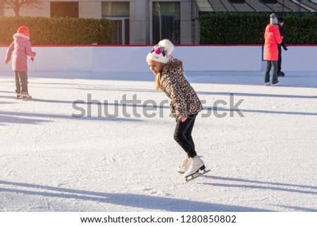  Ice skating.Active outdoor recreation, on the street. Small children skate on the rinks .