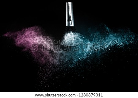 Cosmetic brush with purple and blue ocean cosmetic powder spreading for makeup artist or graphic design in black background, look like a lively and joyful mood.