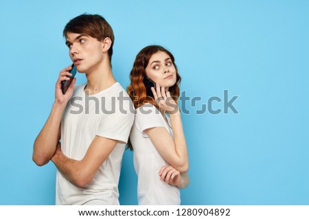 man and woman turned their backs to each other and talking on the phone                          