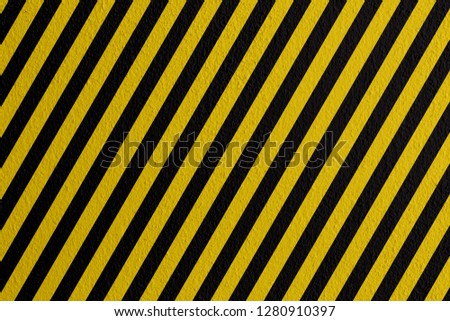 Safety sign yellow and black on mortar texture warning to be careful of the potential danger