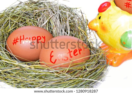 Two red chicken eggs in straw nest with text happy Easter and sign hashtag for social network next ceramic toy yellow hen on white background. 