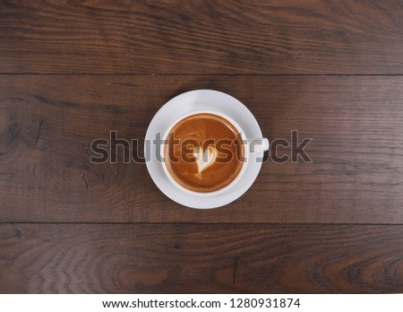 Cup of coffee on the wood table with latte art