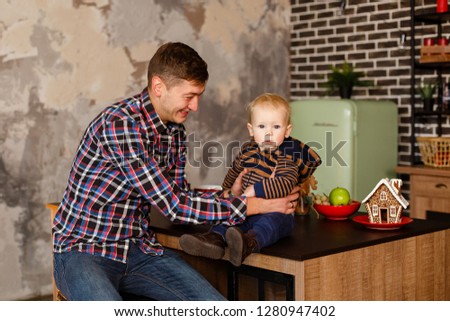 Little boy with his father in Christmas loft interior. Christmas celebration. Boy with Dad weared in casual. New year eve in loft room with red accents. Lighting vintage star on background