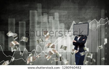 Business woman in suit with TV instead of head keeping arms crossed while standing against flying dollar banknotes and analytical charts drawn on wall on background. 3D rendering.