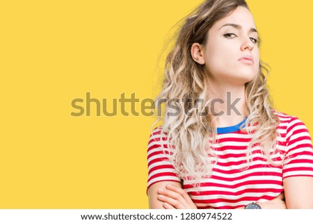 Beautiful young blonde woman over isolated background skeptic and nervous, disapproving expression on face with crossed arms. Negative person.