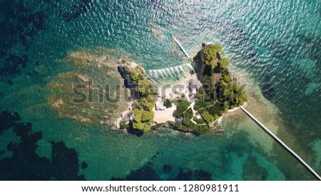 Aerial drone photo of paradise mediterranean island with deep turquoise sea and beautiful white rock volcanic scenery