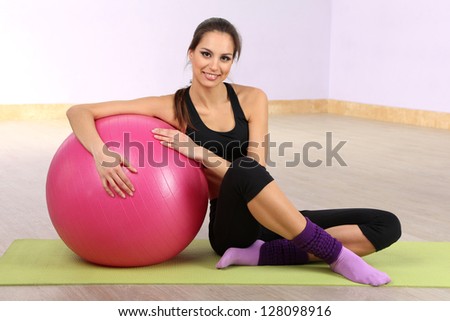 Young woman with gym ball at gymnasium