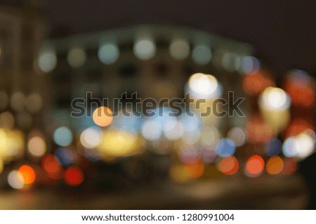 Blurred abstract photo of night street with bright lights, cars and buildings.

