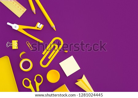 Yellow stationery on a purple background. Back to school creative concept. Flat lay.