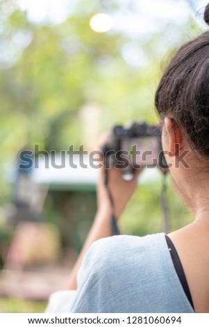 young woman holds camera to take pictures , travel concept- Image