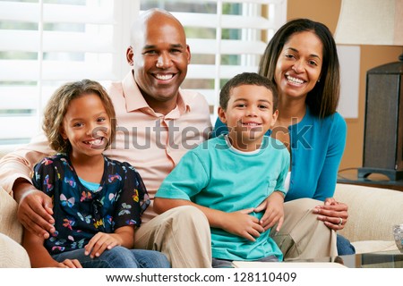 Portrait Of Family Sitting On Sofa Together Royalty-Free Stock Photo #128110409