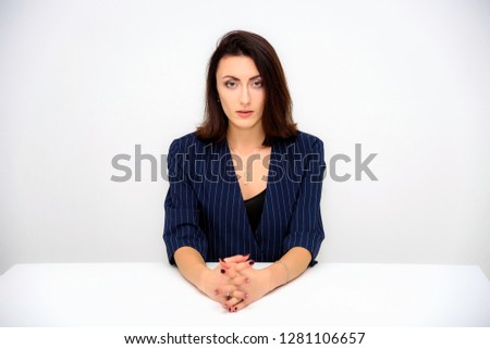 Concept beautiful business woman secretary manager on a white background sitting at a table in various poses right in front of the camera. She works with documents with different emotions.