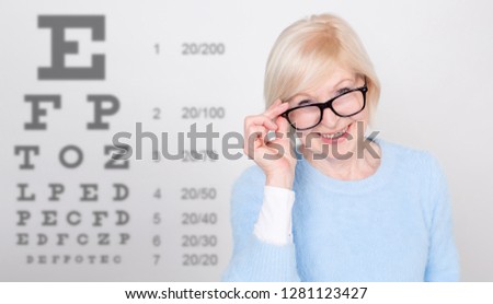 Senior woman in glasses having eye on the vision testing tables background. Visiting a doctor ophthalmologist.  Royalty-Free Stock Photo #1281123427