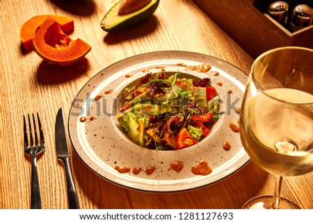 Avocado and Pumpkin Salad and wine white glass