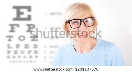 Portrait of senior woman in glasses, having eye on the vision testing tables background. Visiting a doctor ophthalmologist.  Royalty-Free Stock Photo #1281137578