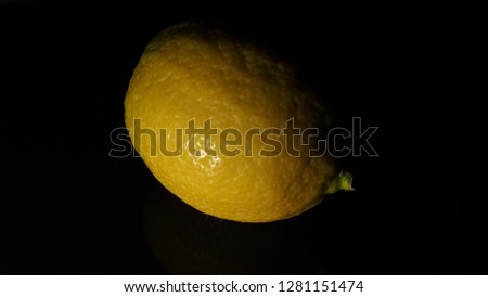 yellow lemon isolated with black bakground and low light