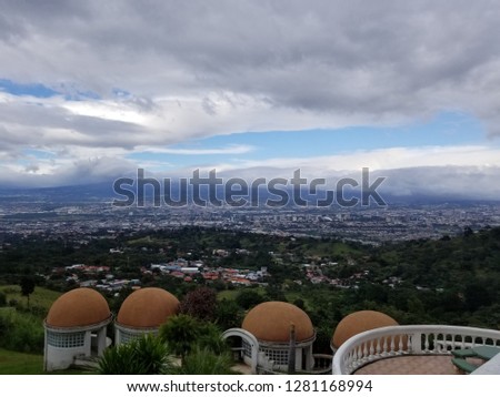 Overlooking the entire city of San Jose Costa Rica and the mountains and volcanoes in the background and showing beauiful clouds over the mountains
