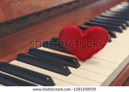 Red cartoon heart put on keyboard's piano, To tell love to learn music or to tell someone love in special day and valentine day.