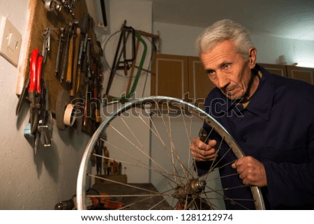 Senior old school mechanic repairing bicycle