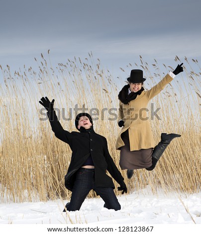 Man and woman posing near winter lake beach
