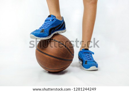 Boy - teenager - basketball player put his foot in a blue sneaker on a basketball