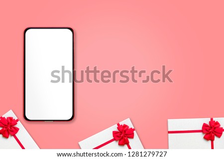 Mobile phone and gift boxes with white ribbon on pink pastel color background. copy space blank screen mock up template add idea design on blank screen. Flat lay minimal Valentine technology concept.