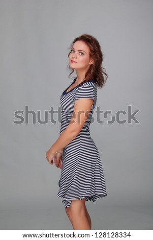 Young woman dancing on grey background