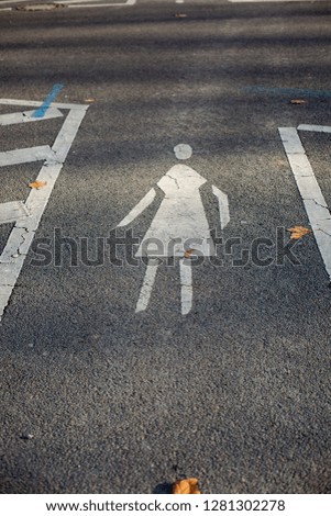 Pedestrian crossing with white markings with a drawn symbol on a small street in Berlin.