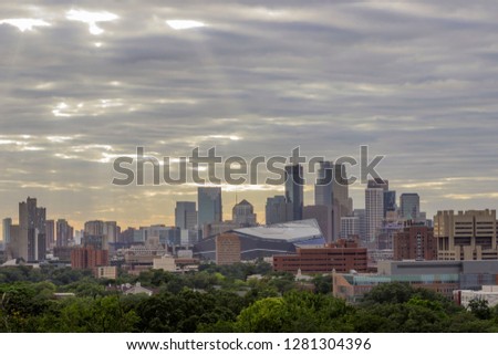 A Medium Cityscape Shot of Minneapolis with Dramatic Sun Rays and Clouds during a Beautiful Summer Afternoon