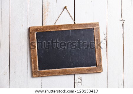 Vintage slate chalk board hanging on wooden background