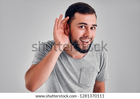Gesture and eople concept - young cute man having hearing problem listening to something Royalty-Free Stock Photo #1281370111