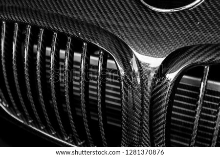 Details of the carbon fiber grille of sports car in black and white.