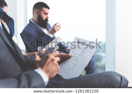 Closeup image of male hand holding glass with whiskey and CV paper, Waiting room for job interviews, Anxiety and stress Royalty-Free Stock Photo #1281381238