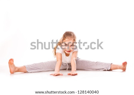 Beautiful girl gymnast  exercising, stretching isolated on white